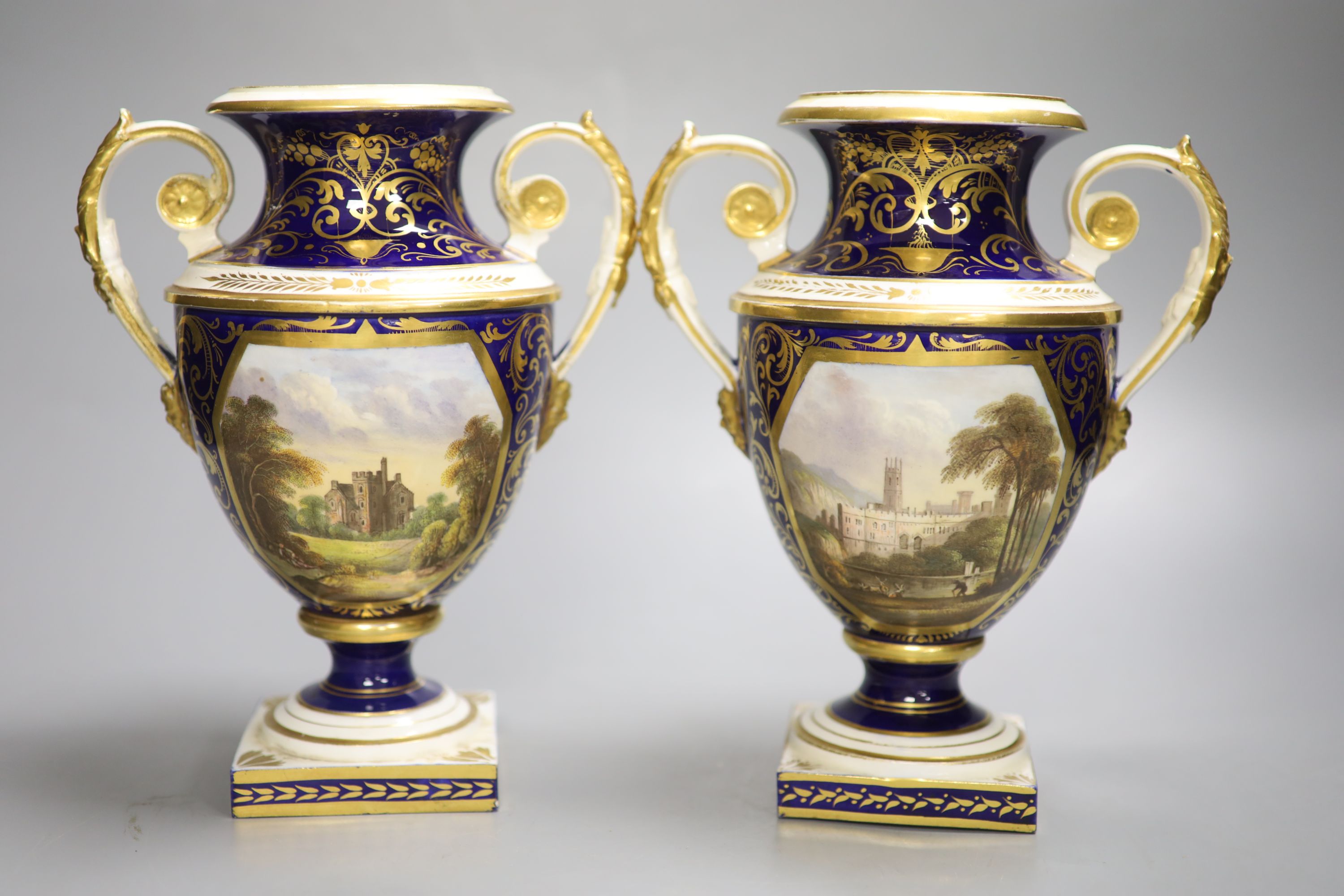 A Derby pair of two handled shield vases, painted with scenes of Old Castle Oxenford and Warwick Castle, height 22cm